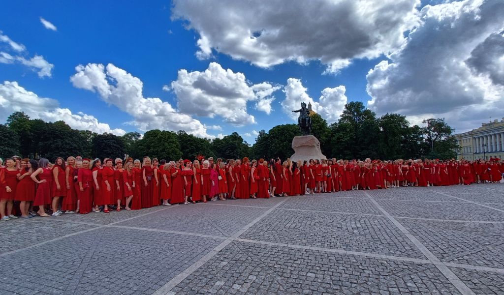 Жительницы Петербурга прошли по центру города в красных платьях в поддержку президента РФ